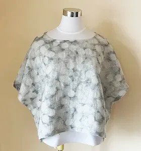 白いしわ加工のリラックスVネックトップスとワイドパンツのセットアップ。
